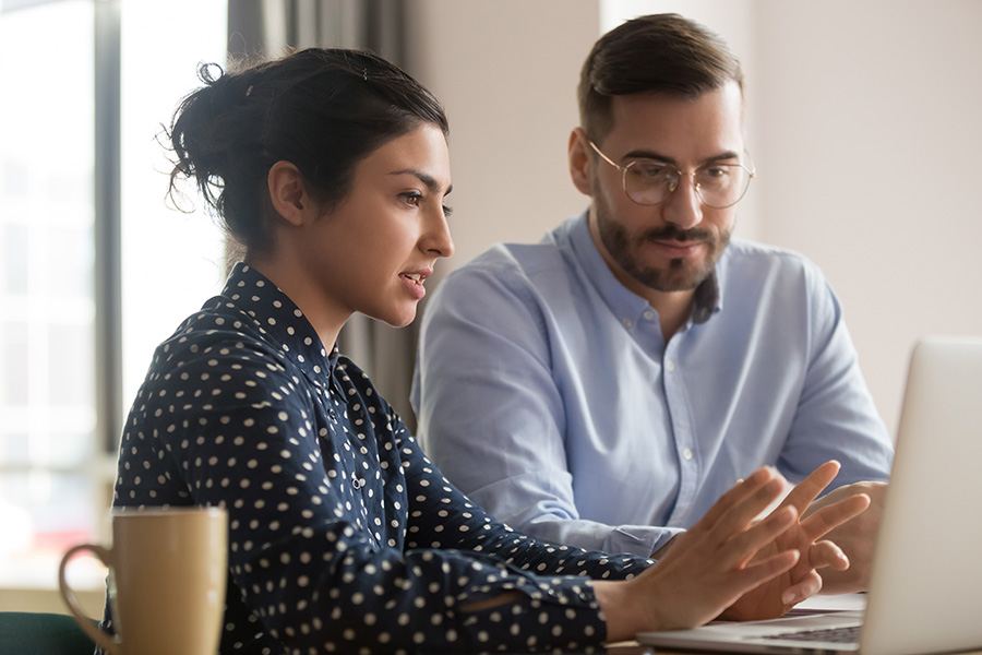 a woman and man working together on a laptop